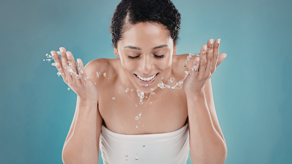 Young Woman Washing Face with Rose Water